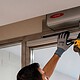 técnico revisando instalación puerta automática en portal de vecinos (Generado por IA)